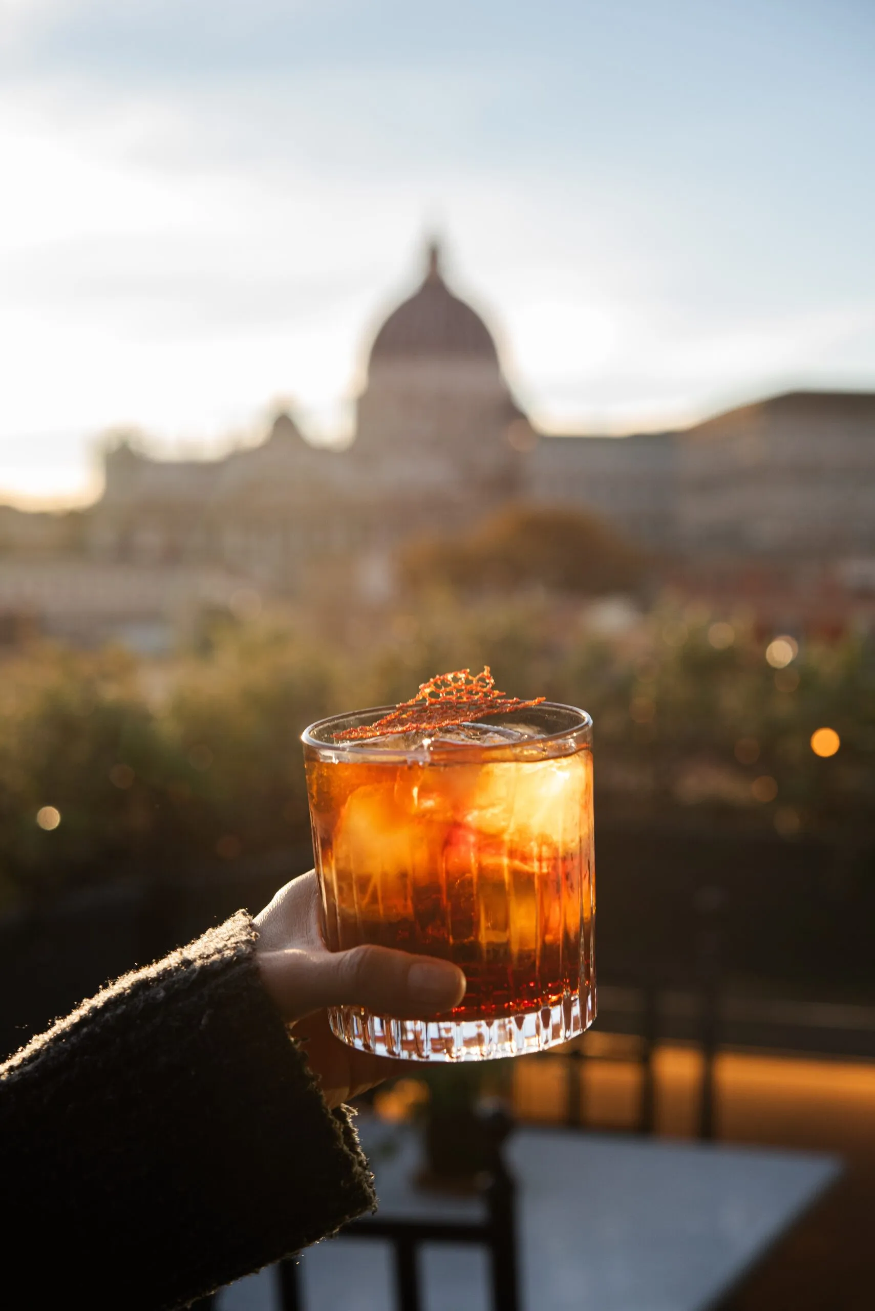 Un drink sul rooftop con la cupola di San Pietro sullo sfondo